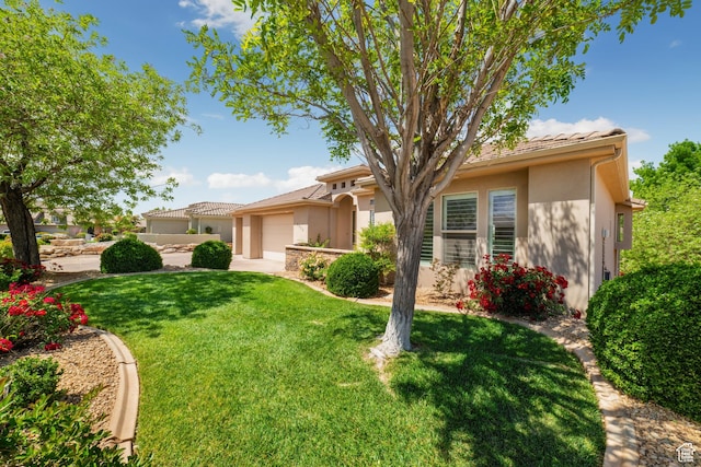view of front of home featuring driveway, a garage, stucco siding, a front lawn, and a tiled roof