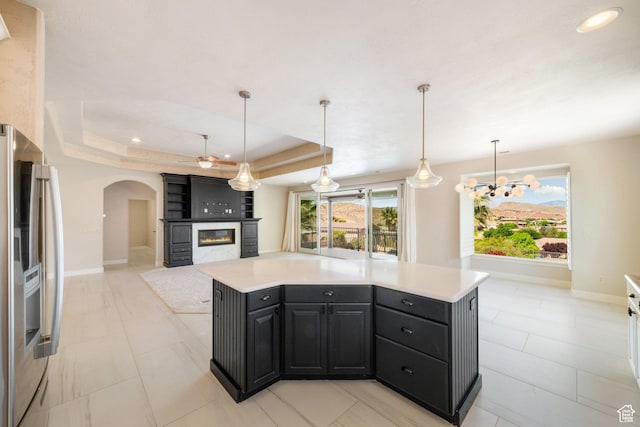 2996 S Limestone Dr, St George, UT 84790 - kitchen with stainless steel fridge, baseboards, arched walkways, a large fireplace, and light countertops