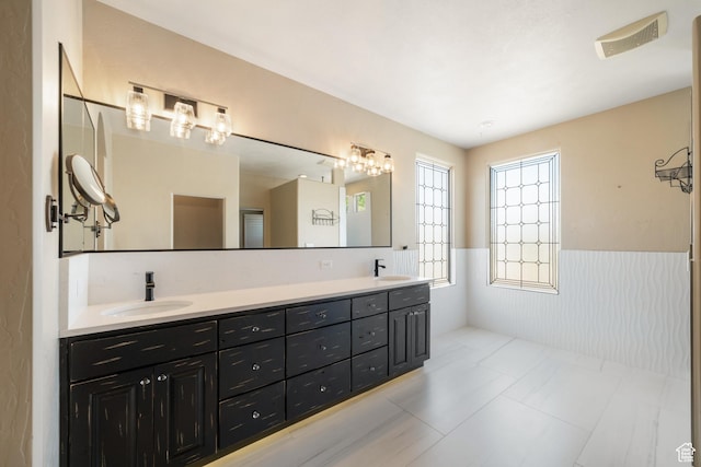 2996 S Limestone Dr, St George, UT 84790 - full bathroom featuring double vanity, a wainscoted wall, visible vents, and a sink