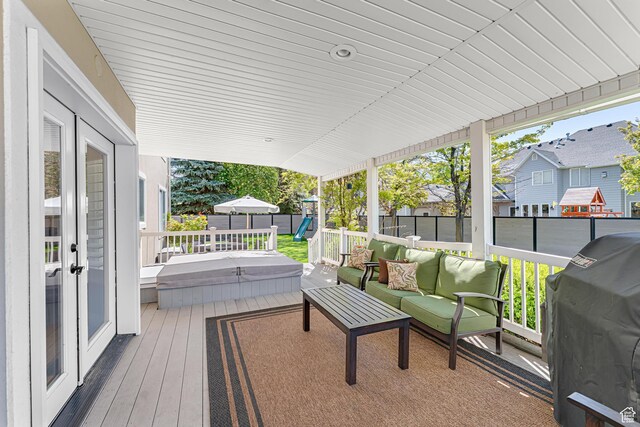 deck featuring a grill, a fenced backyard, an outdoor living space, and a residential view