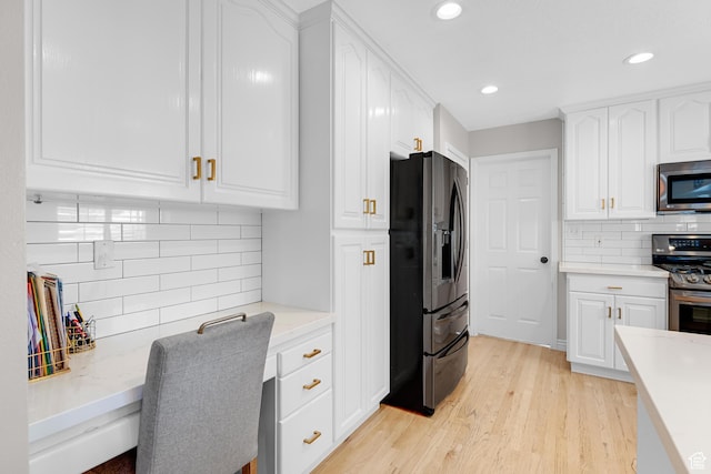 kitchen featuring light wood-style flooring, recessed lighting, backsplash, stainless steel appliances, and white cabinets