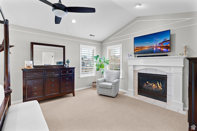 sitting room featuring lofted ceiling, visible vents, light carpet, a ceiling fan, and a tile fireplace