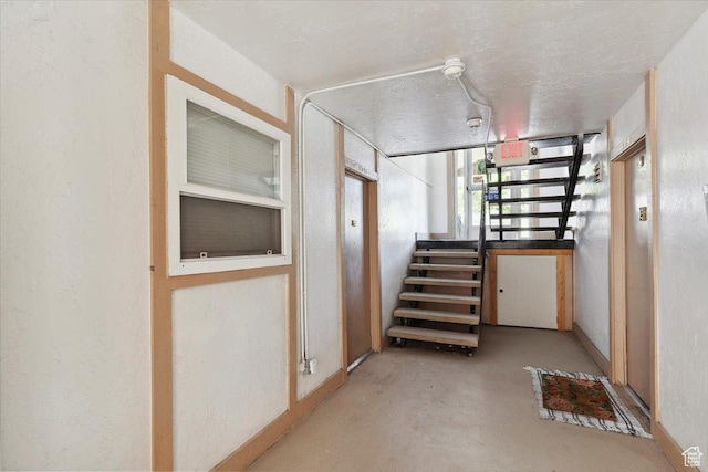 corridor with finished concrete floors and stairs