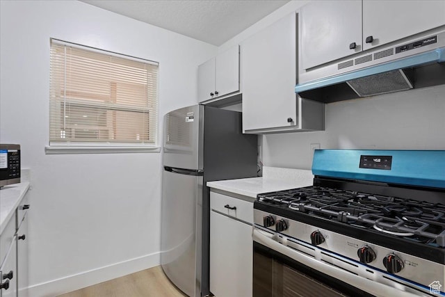 5630 S Meadow Ln E Unit 175, South Ogden, UT 84403 - kitchen featuring stainless steel appliances, under cabinet range hood, light countertops, white cabinets, and baseboards