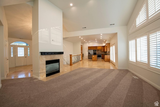 105 S 400 E, Hyde Park, UT 84318 - unfurnished living room with recessed lighting, a tile fireplace, visible vents, high vaulted ceiling, and light carpet