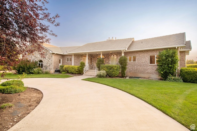105 S 400 E, Hyde Park, UT 84318 - ranch-style home with curved driveway, a tiled roof, brick siding, and a front yard