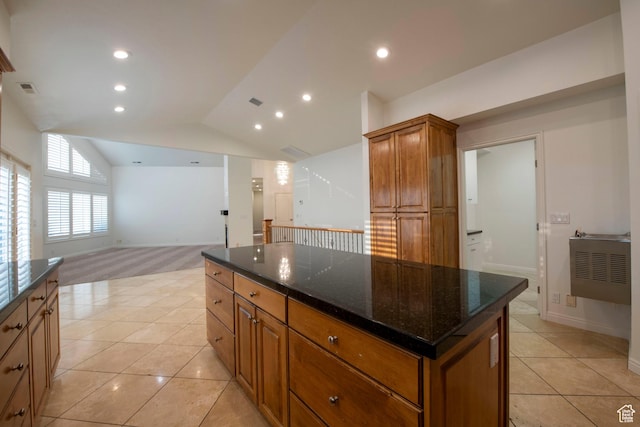 105 S 400 E, Hyde Park, UT 84318 - kitchen featuring lofted ceiling, light tile patterned flooring, dark stone countertops, a kitchen island, and brown cabinets