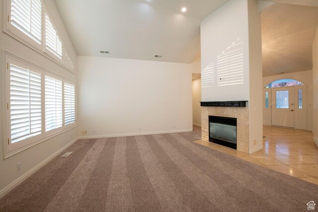 105 S 400 E, Hyde Park, UT 84318 - unfurnished living room featuring light colored carpet, a wealth of natural light, high vaulted ceiling, and visible vents
