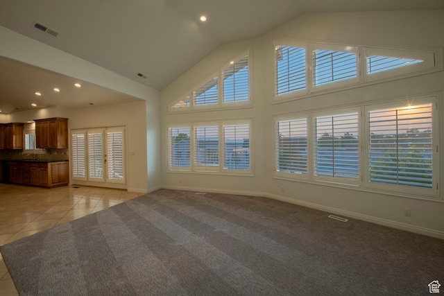 105 S 400 E, Hyde Park, UT 84318 - unfurnished living room featuring light colored carpet, high vaulted ceiling, visible vents, light tile patterned floors, and baseboards