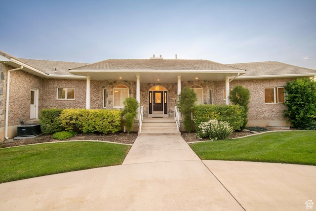 105 S 400 E, Hyde Park, UT 84318 - ranch-style home featuring a front lawn, brick siding, a porch, and central AC
