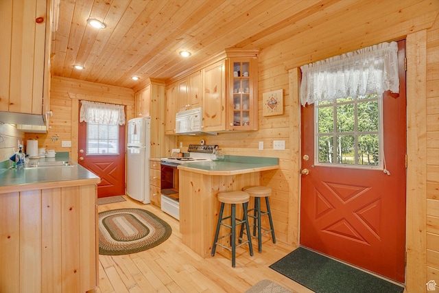 4571 Fawn Way, Heber City, UT 84032 - kitchen with wood ceiling, a breakfast bar area, wood walls, white appliances, and light wood-style floors