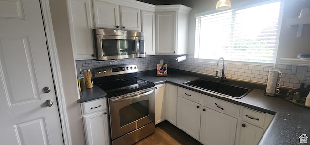 3391 W 1125 N, Layton, UT 84040 - kitchen featuring stainless steel appliances, a sink, dark countertops, white cabinetry, and tasteful backsplash