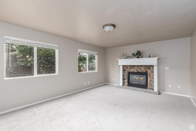 3391 W 1125 N, Layton, UT 84040 - unfurnished living room featuring carpet flooring, baseboards, and a stone fireplace