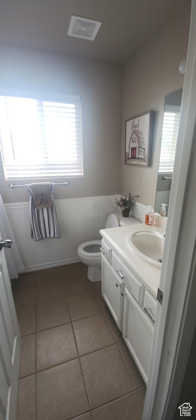 3391 W 1125 N, Layton, UT 84040 - half bathroom with healthy amount of natural light, tile patterned floors, vanity, a wainscoted wall, and toilet