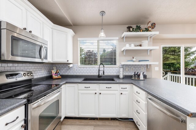 3391 W 1125 N, Layton, UT 84040 - kitchen with stainless steel appliances, a sink, backsplash, dark countertops, and white cabinets