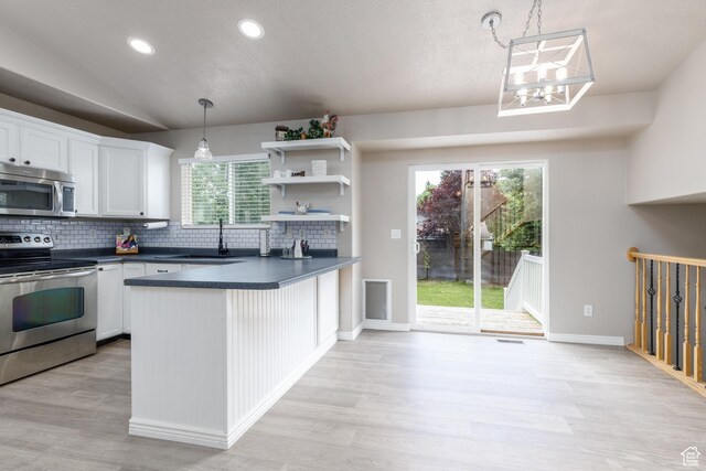 3391 W 1125 N, Layton, UT 84040 - kitchen with appliances with stainless steel finishes, a sink, dark countertops, backsplash, and light wood finished floors