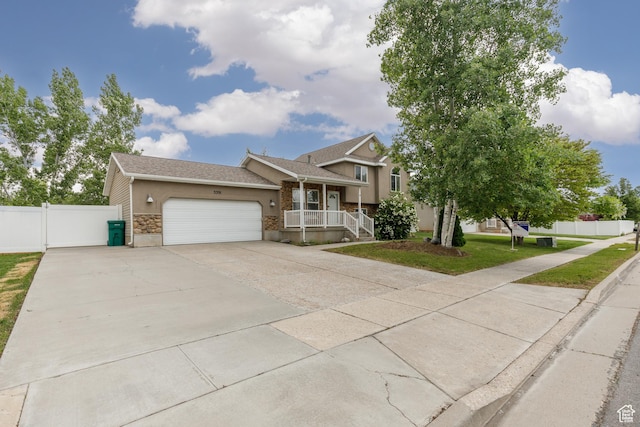 3391 W 1125 N, Layton, UT 84040 - split level home featuring stone siding, a garage, a porch, driveway, and stucco siding