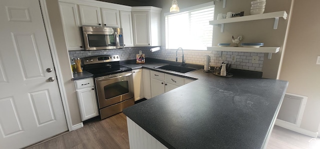 3391 W 1125 N, Layton, UT 84040 - kitchen featuring stainless steel appliances, a sink, open shelves, dark countertops, and wood finished floors