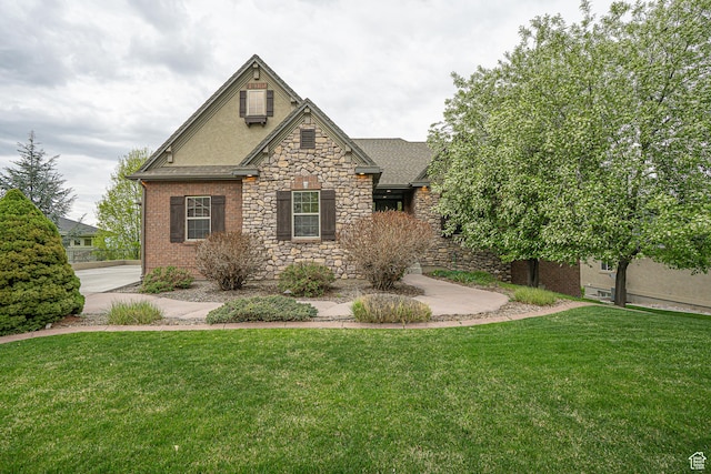 craftsman house with stone siding, a shingled roof, and a front yard
