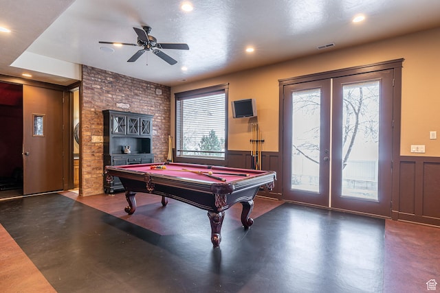 playroom featuring pool table, french doors, ceiling fan, a wainscoted wall, and concrete flooring