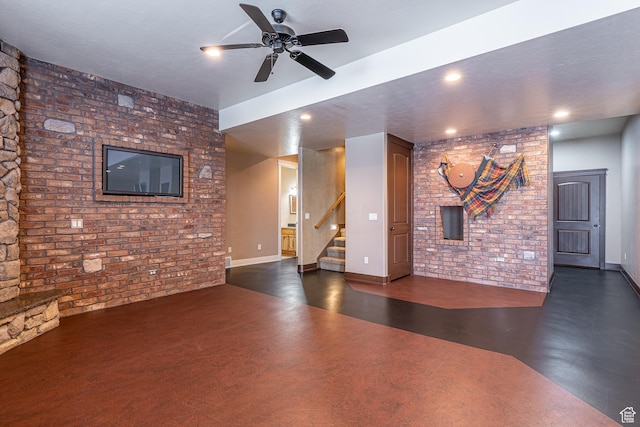 unfurnished living room with recessed lighting, brick wall, a ceiling fan, and stairs
