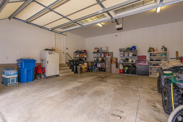 garage with freestanding refrigerator and a garage door opener
