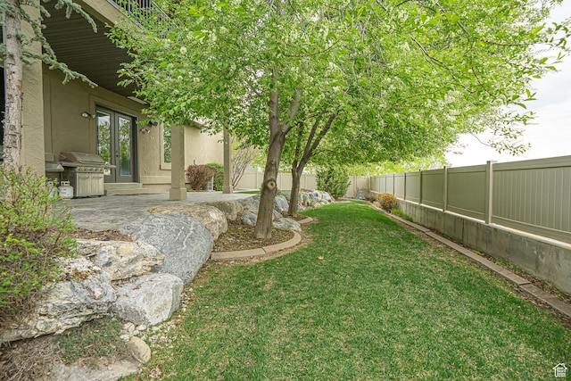 view of yard featuring a patio, french doors, and a fenced backyard
