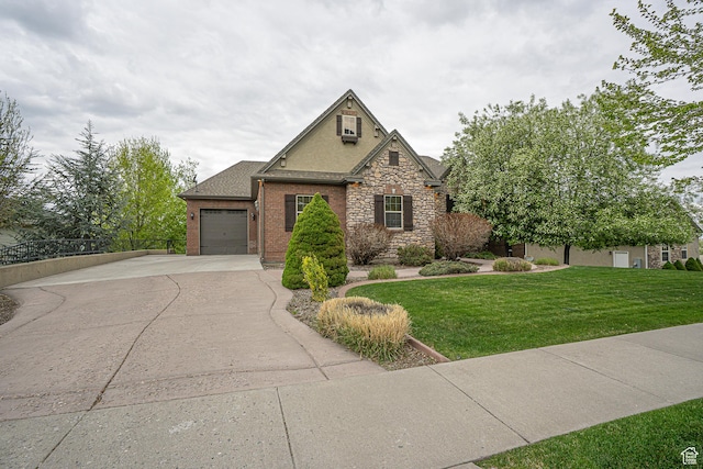 view of front of home with concrete driveway, an attached garage, a front yard, and stone siding
