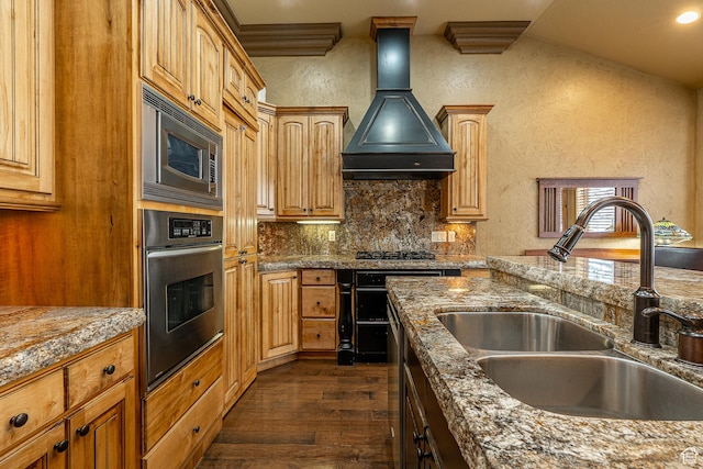 kitchen featuring a sink, dark wood-style flooring, a textured wall, appliances with stainless steel finishes, and premium range hood
