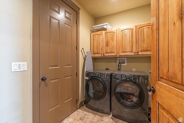 clothes washing area featuring cabinet space and independent washer and dryer