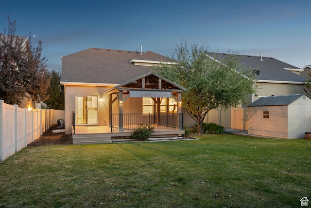 rear view of property featuring a storage shed, a deck, an outdoor structure, a gazebo, and a fenced backyard