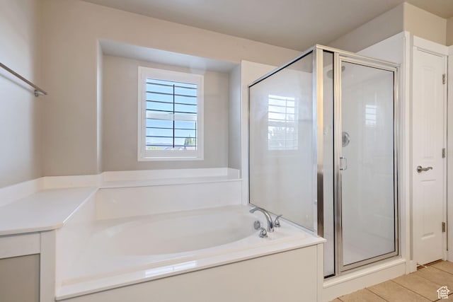 full bath with a stall shower, tile patterned flooring, and a bath