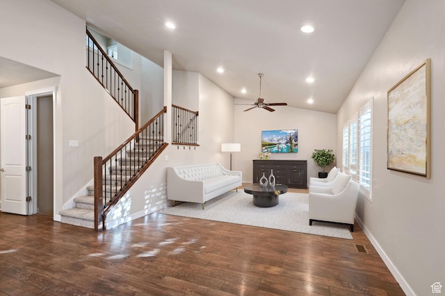 living area with wood-type flooring, stairway, baseboards, ceiling fan, and vaulted ceiling