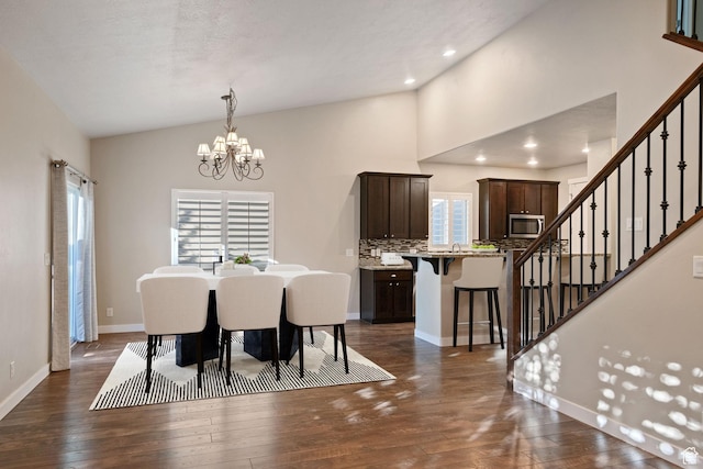 dining area with stairs, vaulted ceiling, a chandelier, dark wood-style flooring, and baseboards