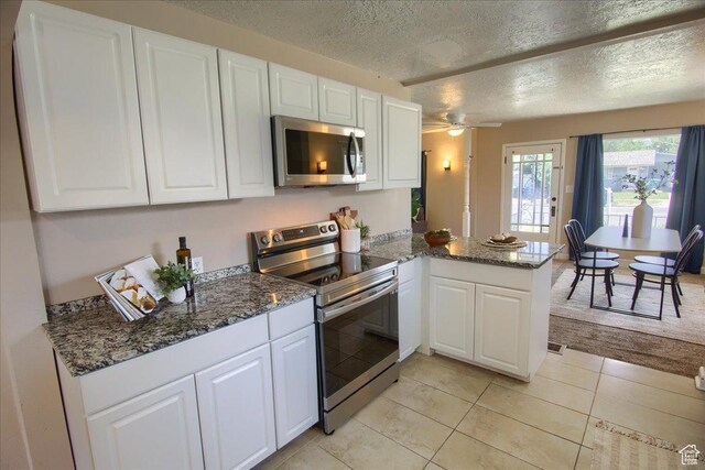 3417 S Lincoln Ave, Ogden, UT 84401 - kitchen with stainless steel appliances, a peninsula, a textured ceiling, white cabinetry, and ceiling fan