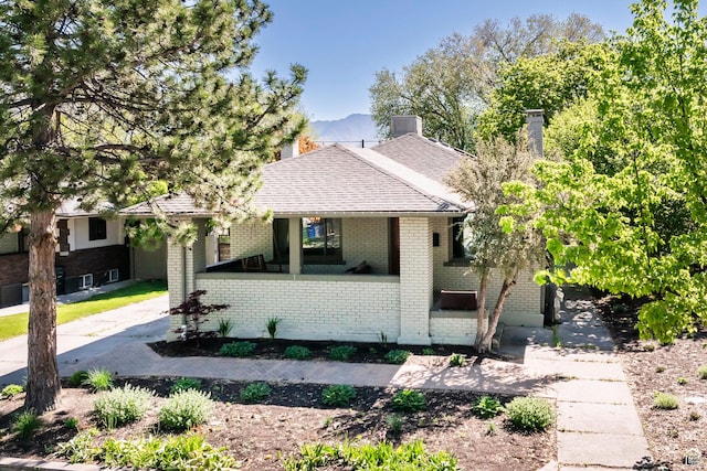 1991 S 800 E, Salt Lake City, UT 84105 - view of front of house featuring covered porch, roof with shingles, a mountain view, brick siding, and a chimney
