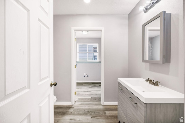 736 Majestic Dr, Logan, UT 84321 - bathroom with wood finished floors, vanity, toilet, and baseboards