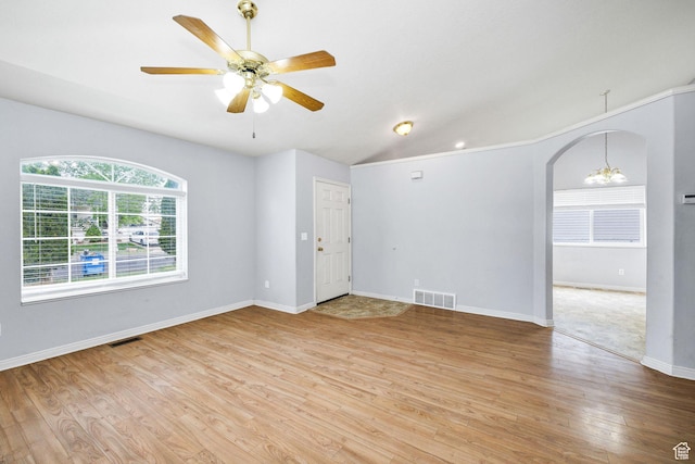 736 Majestic Dr, Logan, UT 84321 - empty room with light wood-style flooring, ceiling fan, arched walkways, a chandelier, and baseboards