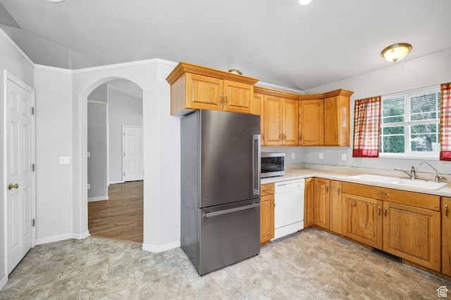736 Majestic Dr, Logan, UT 84321 - kitchen with stainless steel appliances, a sink, light countertops, arched walkways, and brown cabinetry