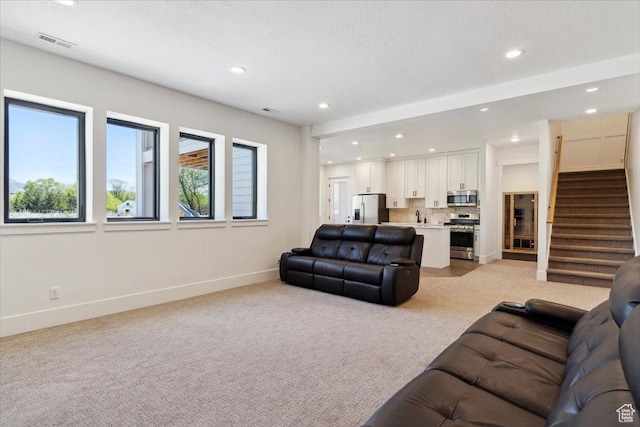 living room featuring baseboards, recessed lighting, light carpet, and visible vents