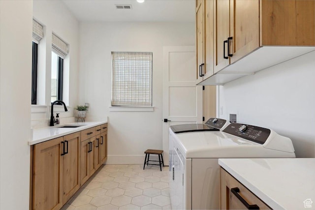 washroom featuring light tile patterned floors, a sink, cabinet space, visible vents, and independent washer and dryer