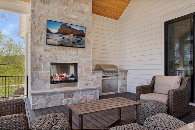 view of patio featuring a grill, an outdoor kitchen, and an outdoor stone fireplace