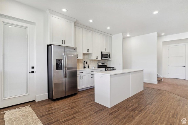 kitchen featuring a sink, white cabinetry, backsplash, light countertops, and appliances with stainless steel finishes