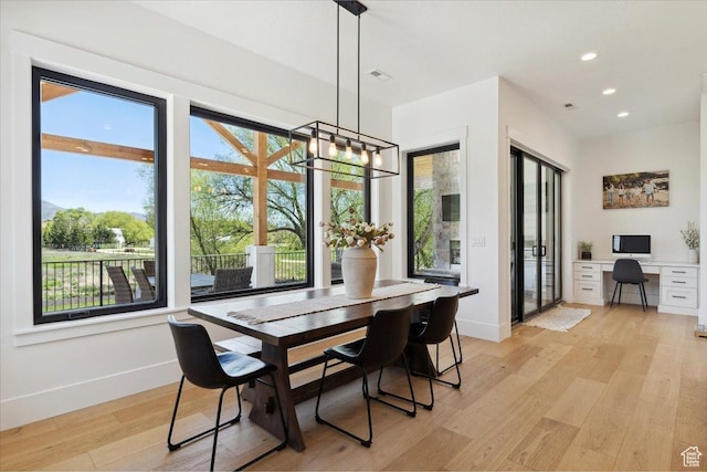 dining room featuring light wood finished floors, baseboards, a notable chandelier, and recessed lighting
