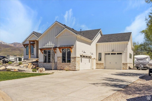 view of front of house featuring stone siding, board and batten siding, a garage, and concrete driveway