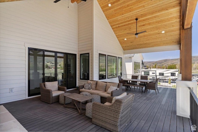 deck featuring a mountain view, a ceiling fan, and outdoor dining space