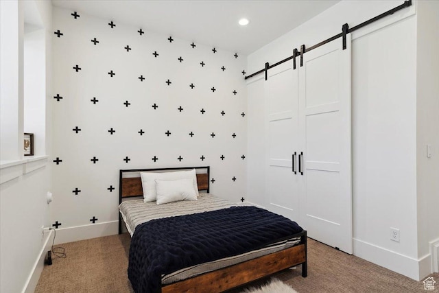 bedroom featuring light colored carpet, a barn door, baseboards, and recessed lighting