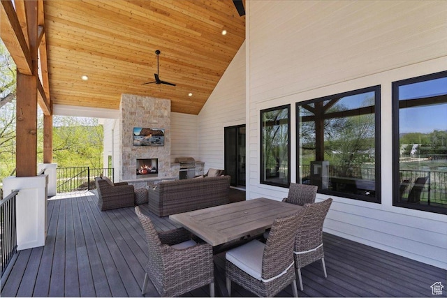 wooden terrace with an outdoor living space with a fireplace