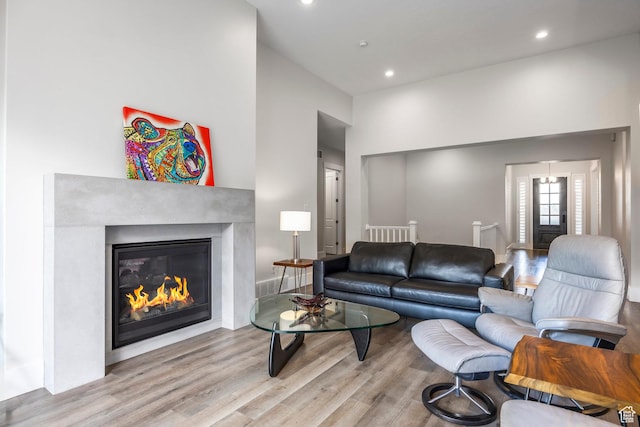 9293 S Regatta Ln, Cottonwood Heights, UT 84093 - living room with recessed lighting, a high ceiling, a glass covered fireplace, and wood finished floors