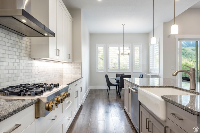9293 S Regatta Ln, Cottonwood Heights, UT 84093 - kitchen with a sink, dark stone countertops, backsplash, wall chimney range hood, and appliances with stainless steel finishes